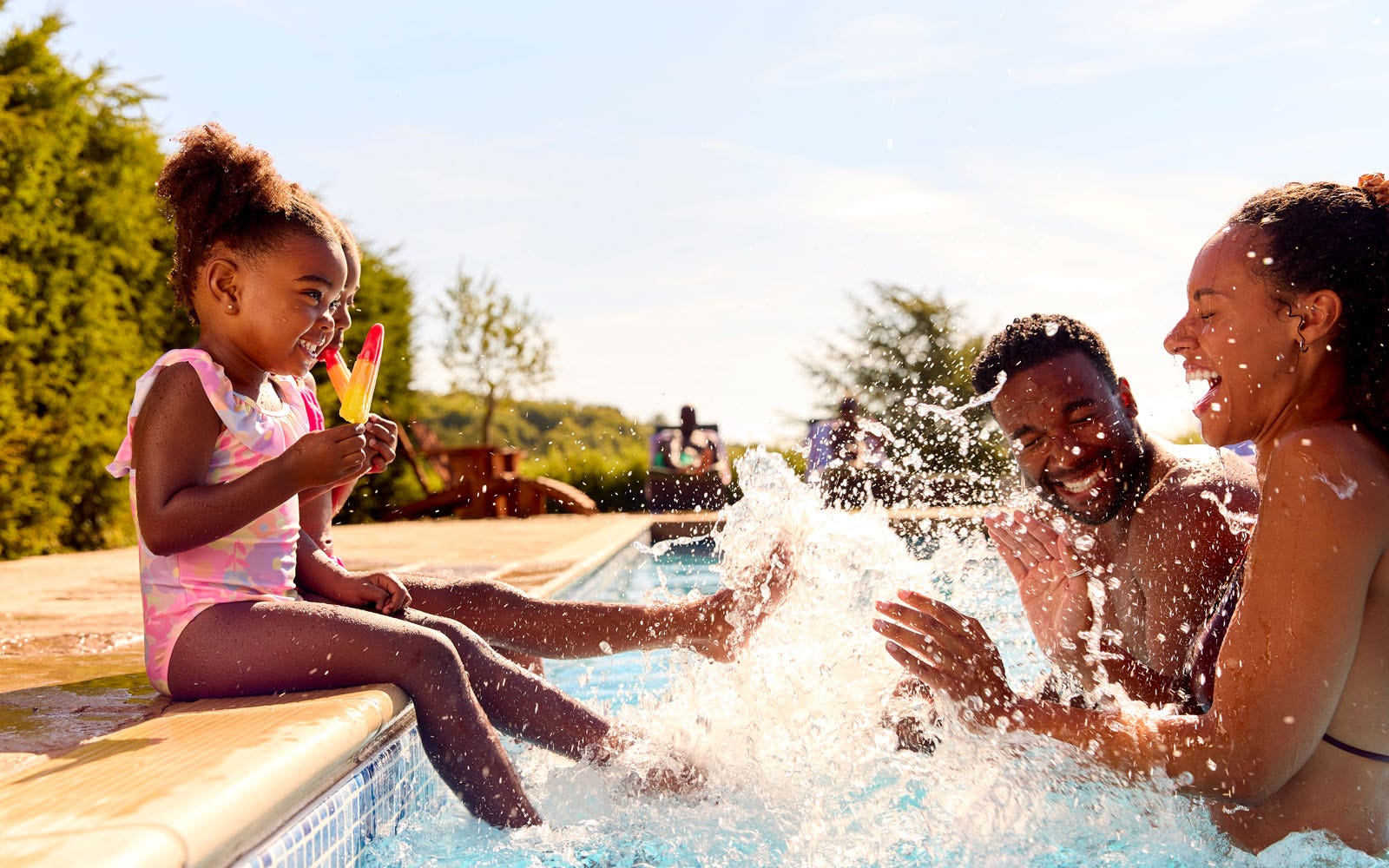 family playing with their kids at pool